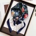 Détail d'un foulard en soie aux motifs floraux avec bords roulés sur fond vintage - Bleu foncé