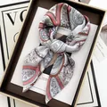 Detalle de un pañuelo de seda con estampado paisley anudado sobre una revista de moda - Estilo Paisley Floral Rosa y Azul (37)