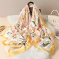 Détail d'un foulard en satin de soie à imprimé floral drapé sur un sac à main chic - Jaune