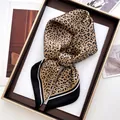 Detail of leopard print silk scarf with black borders on an elegant display tray - Khaki