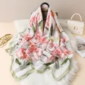 Détail d'un foulard en satin à fleurs de tulipes roses sur de la fausse fourrure blanche - Vert clair