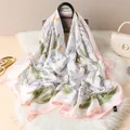 Détail de la texture d'un foulard floral en polyester satiné sur un sac à main - Style à Bord Rose