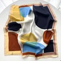 Detailed close-up of a geometric satin silk square scarf with abstract color block patterns - Yellow