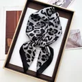 Close-up of leopard print silk scarf in a premium gift box with elegant packaging - Black