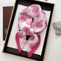 Dettaglio di sciarpa in seta con stampe di conchiglie rosa e bordo su sfondo artistico - Stile Motivo Conchiglia Rosa e Bianco (1) / bianco-rosa