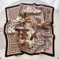 Détail d'un luxueux foulard carré en soie avec motif imprimé léopard et feuilles de palmier - Café