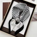 Elegant black and white striped silk scarf presented in a luxury golden gift box - Black