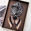 Macro detail of silk-like neckerchief with leopard print and orange striped pattern - Khaki