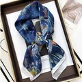 Detail of navy blue silk scarf with dragonfly and floral print on display tray - Dark Blue
