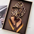 Macro view of leopard print silk scarf with striped border on a stylish display tray - Coffee