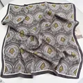 Vista dall'alto di un foulard di seta quadrato con motivi paisley grigi e gialli sul tavolo - Fazzoletto / Grigio