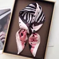 Pink and white silk square scarf with zebra pattern on a golden tray with magazines - Zebra Pink