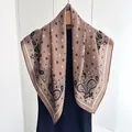 Brown paisley square silk scarf with floral patterns on a hanger with a black sweater - Pink