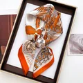 Detail of vibrant orange silk scarf with feather and leopard prints on a wooden tray - Large Square / Orange Leopard Palm (24)