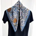 Detailed view of paisley silk scarf in blue and ginger yellow on a black t-shirt - Blue White Yellow Paisley Style (Style 1)