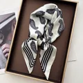 Detail of silk-satin scarf featuring black paisley patterns and striped borders - White