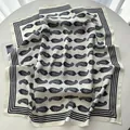 Detail of off-white paisley silk scarf showing soft fabric folds and navy border - Cream Black Paisley (2)