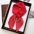 Primo piano di un foulard in seta a pois rossi e bianchi in una confezione regalo dorata - Foulard a Pois Rosso / Rosso