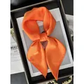 Glossy vibrant orange silk satin square scarf shown as an elegant knotted fashion accessory - Orange Red