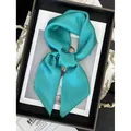 Carré de soie vert lagon en satin brillant présenté élégamment sur un plateau chic - Bleu sarcelle