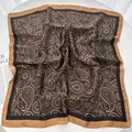 Detail eines luxuriösen Seidenschals mit Paisley- und Blumenmuster in Camel und Schwarz - Schwarz
