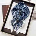 Elegant white paisley print silk scarf in dark blue tones displayed on a fashion magazine - Paisley Pattern / White