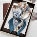 Detail of elegant floral square scarf with blue and brown patterns in a gift tray - Lake Blue