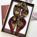 Navy blue paisley satin scarf with red borders displayed elegantly in a gold tray - Printed Square Scarf / Navy Paisley (42)