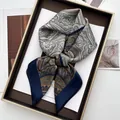 Close-up of vintage paisley satin scarf in olive green and navy blue gift box - Blue