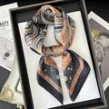 Detail eines Vintage-Seidenschals mit Paisley-Muster in Marineblau und Orange im Rahmen - Schwarz