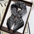 Nahaufnahme eines schwarz-weißen Paisley-Seidenschals, der als Schleife gebunden ist - Knoten-Krawatte Paisley Stil (13) / Schwarz Weiß