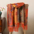 Detailed view of orange ethnic shawl with blue floral patterns and tassel fringe - Orange Red