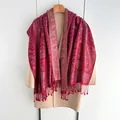 Elegant deep red paisley shawl with long tassels paired over a beige winter coat - Red