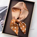 Orange and white polka dot silk square scarf displayed elegantly on a luxury tray - Rectangular Brown
