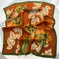Détail d'un foulard en soie à fleurs orange et vertes posé sur une table avec un magazine - Orange Jaune Bord Vert Floral (22)