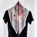 Sciarpa di seta con fiori rosa e grigi e pois neri esposta su un manichino - Rosa