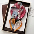 Dettaglio del motivo floreale del foulard in seta e bordo arrotolato arancione in una scatola - Motivo Floreale Vintage (1)