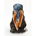 Blue paisley silk square scarf worn as a headband with orange and white striped borders - Orange