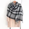 Detail of classic black and white plaid scarf with fringe on a beige wool coat - Black