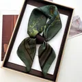 Detail eines Vintage Seidenschals mit Reitmuster in einer Geschenkbox mit Goldrand - Vintage Reitdruck (Olivgrün) / Olivgrün