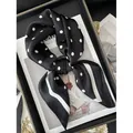 Élégant foulard carré en soie à pois noir et blanc noué sur un magazine de mode - Style à Rayures et Pois Noir et Blanc (21)
