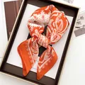 Elegant orange and white paisley silk square scarf folded neatly on a wooden tray - Orange Paisley Pattern Style (10)