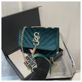 Dettaglio borsa in velluto verde scuro con trapuntatura a V e nappa a catena dorata - Verde