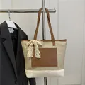 Χειροποίητη ψάθινη τσάντα με δερμάτινα λουράκια και λευκό δαντελένιο φιόγκο σε κρεμάστρα - Μπεζ