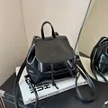 Minimalist black shiny faux leather mini backpack with flap closure and adjustable straps - Black