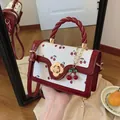 Schattige crossbodytas met kersenprint, gedraaid handvat en bloemsluiting in wit en rood - Rood