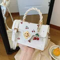 Witte crossbodytas met kersenprint, gedraaid handvat en gouden bloemsluiting - Wit