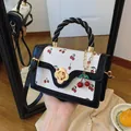 Schattige crossbody tas met kersenprint, gevlochten handvat en bloem draaislot - Zwart