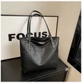 Large black woven faux leather tote bag with sturdy shoulder straps and spacious design - Black