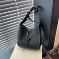 Minimalist black leather bucket bag with white contrast stitching and gold metal buckle - Black